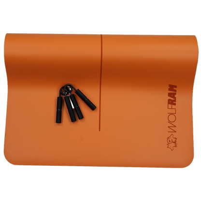 Wolfram Fitness orange yoga mat shown with two black hand grips, highlighting heavy-duty grip strength trainers designed for forearm, wrist and hand conditioning