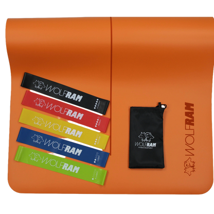 Orange Wolfram Fitness yoga mat showcasing a 5-piece set of latex booty bands in assorted resistance levels, arranged with the included carry bag.