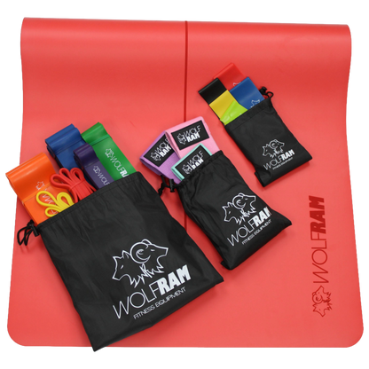 Red Wolfram Fitness yoga mat displaying all resistance band sets in their bags, including the 6-piece long resistance bands, 5-piece latex booty bands, and 3-piece knitted bands.